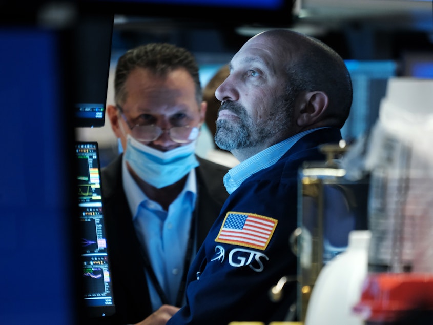 caption: Traders work on the floor of the New York Stock Exchange (NYSE) in New York City on Thursday. Stocks fell sharply a day after the Fed raised interest rates by the most in decades.