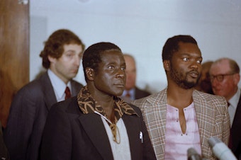 caption: Zimbabwe African National Union leader Robert Mugabe in Geneva, Switzerland, 1976. Others are unidentified.