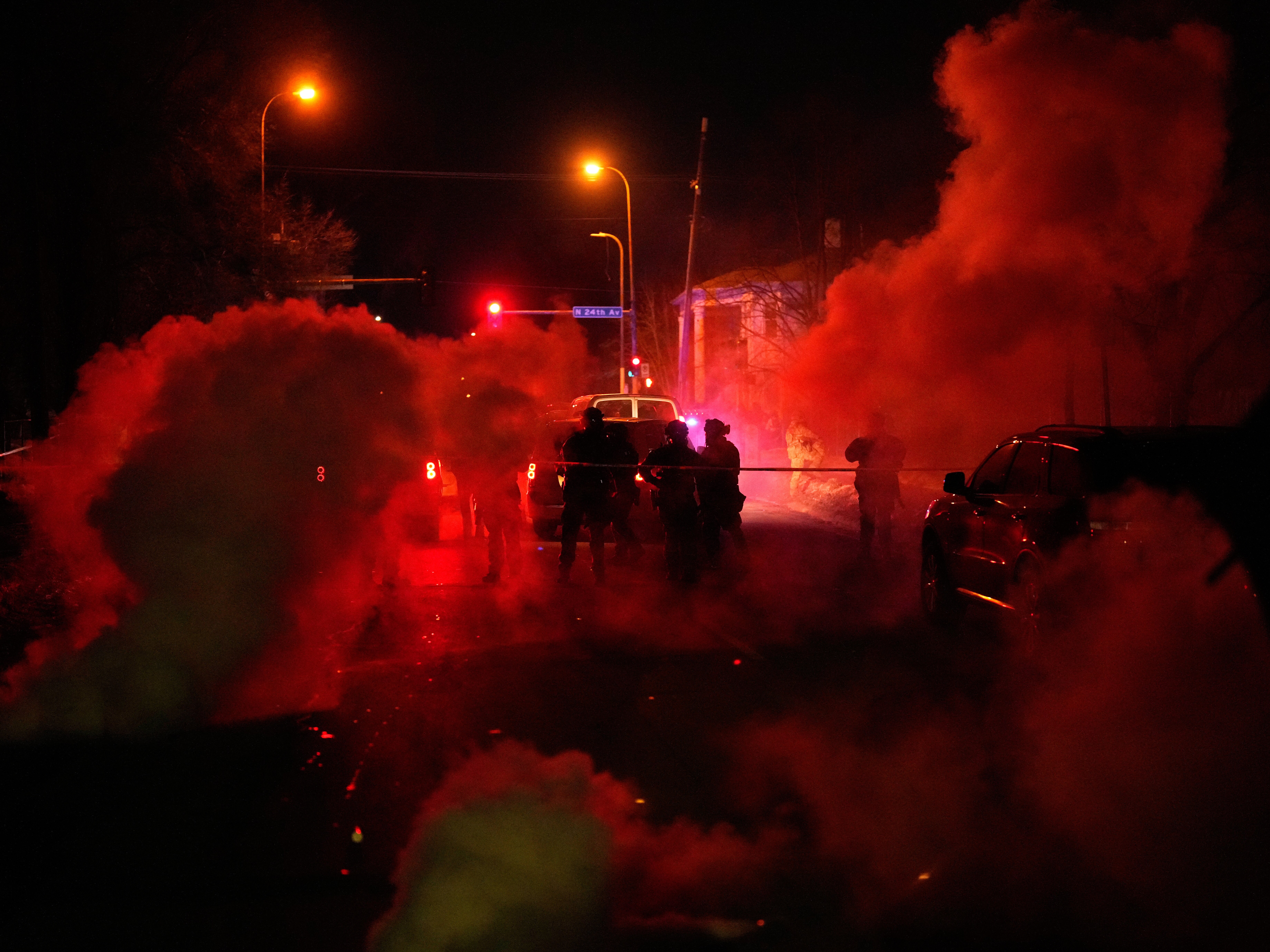 caption: Tear gas surrounds federal law enforcement officers as they leave a scene after a shooting on Wednesday, Jan. 14, 2026, in Minneapolis.