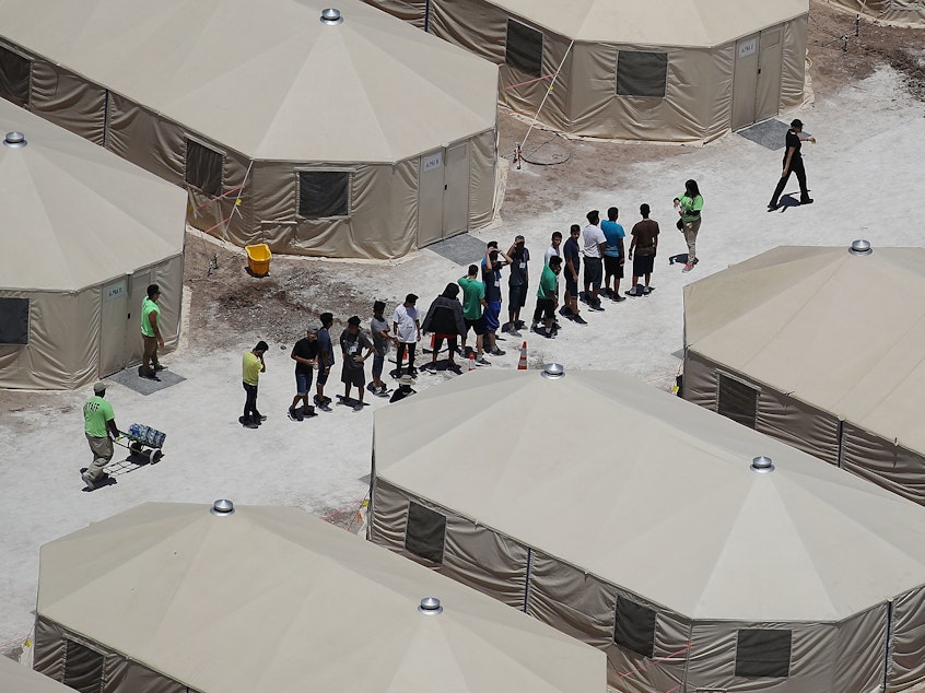 caption: Children and workers are seen at a tent encampment built near the Tornillo Port of Entry in June in Tornillo, Texas.