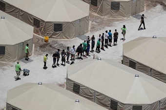 caption: Children and workers are seen at a tent encampment built near the Tornillo Port of Entry in June in Tornillo, Texas.