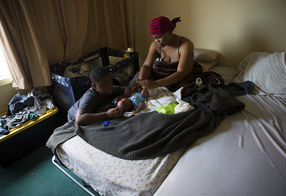 caption: Tiffany Hicks changes her newborn son Elijah's diaper on Sunday, September 3, 2017, in their room at Mary's Place in Seattle.