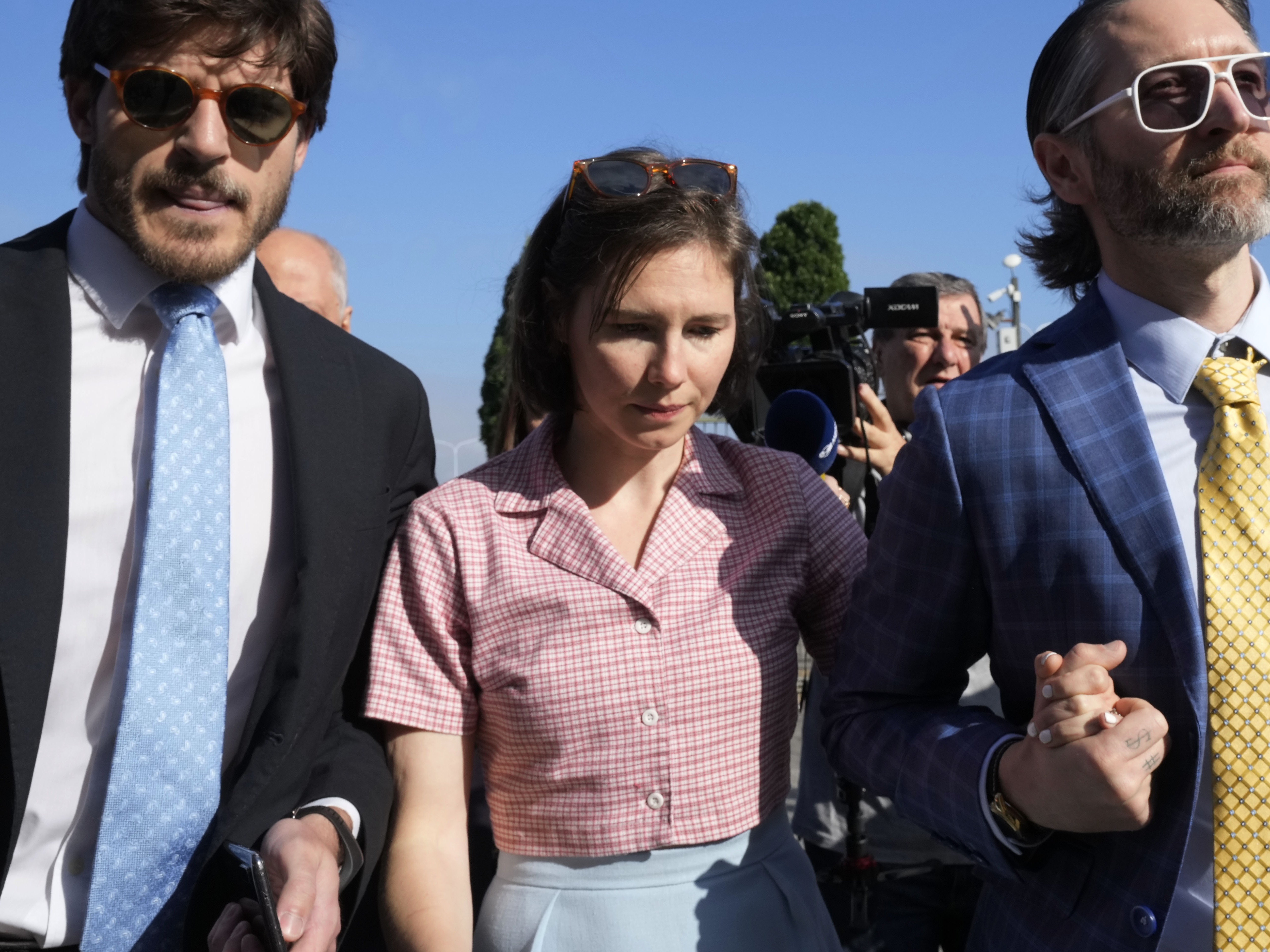 caption: Amanda Knox arrives flanked by her husband Christopher Robinson, right, at the Florence courtroom in Florence, Italy, on Wednesday.
