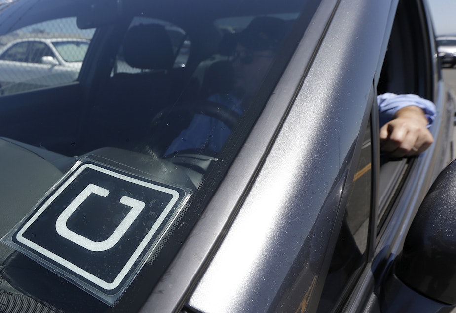 caption: File photo of Uber driver at near the San Francisco International Airport.