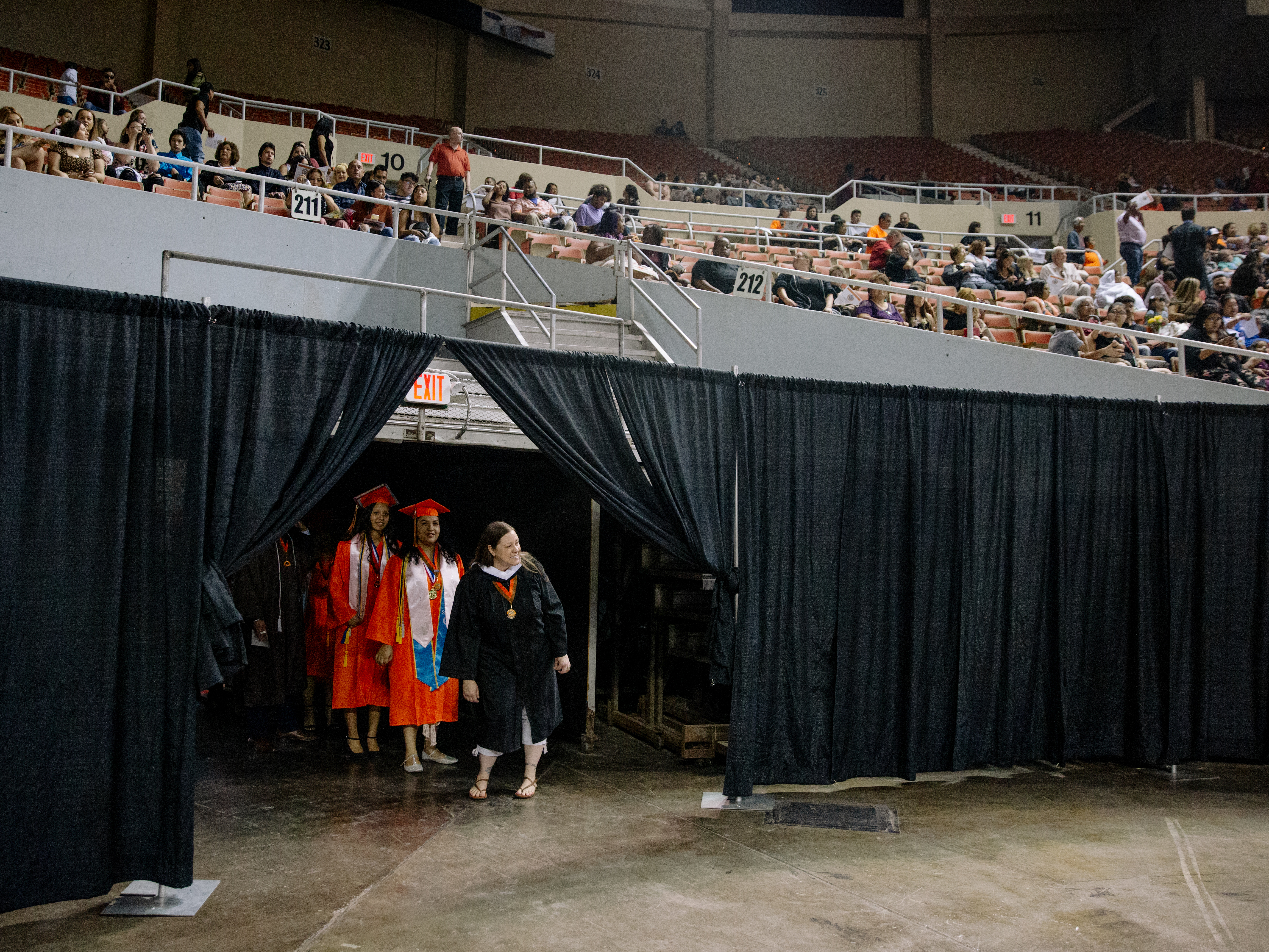 caption: Salutatorian Paulette Olivas, left, stages with fellow Trevor G. Browne High School graduates at the Veterans Colosseum before 2019 Commencement in Phoenix, Ariz.