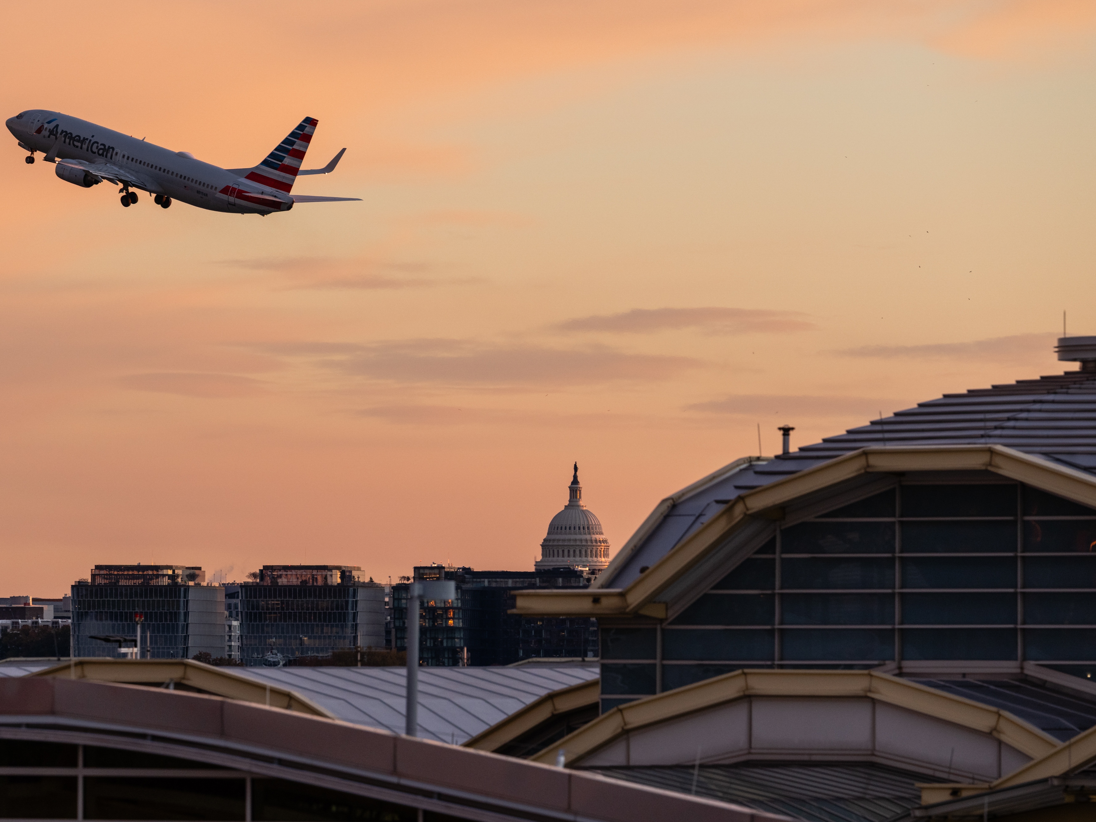 caption: A flight takes off from Reagan Washington National Airport in Arlington, Va., on Tuesday, with the U.S. Capitol in view. The federal government reopened Wednesday, but some of the impacts will be felt longer.