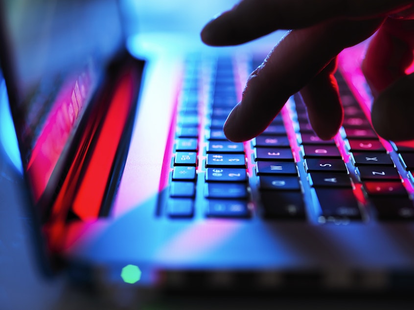 Shown is a laptop keyboard and fingers typing