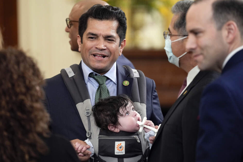 caption: Rep. Jimmy Gomez, D-Calif., arrives with his son Hodge, for an event in the East Room of the White House on March 23, 2023. (Susan Walsh/AP)