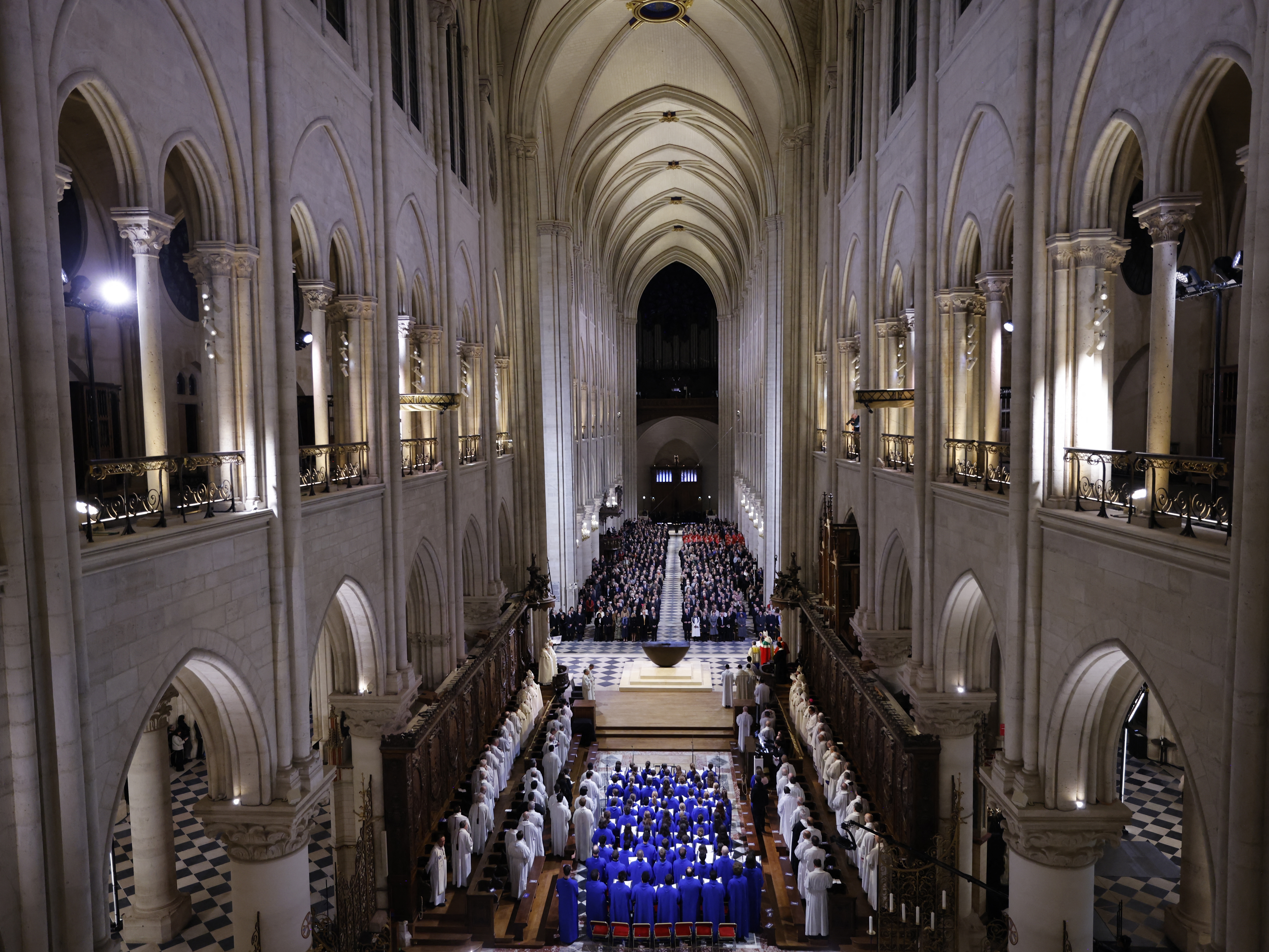 caption: The choir, clergy and guests stand as they sing during a ceremony to mark the reopening of the landmark Notre-Dame Cathedral, in central Paris, on Saturday.