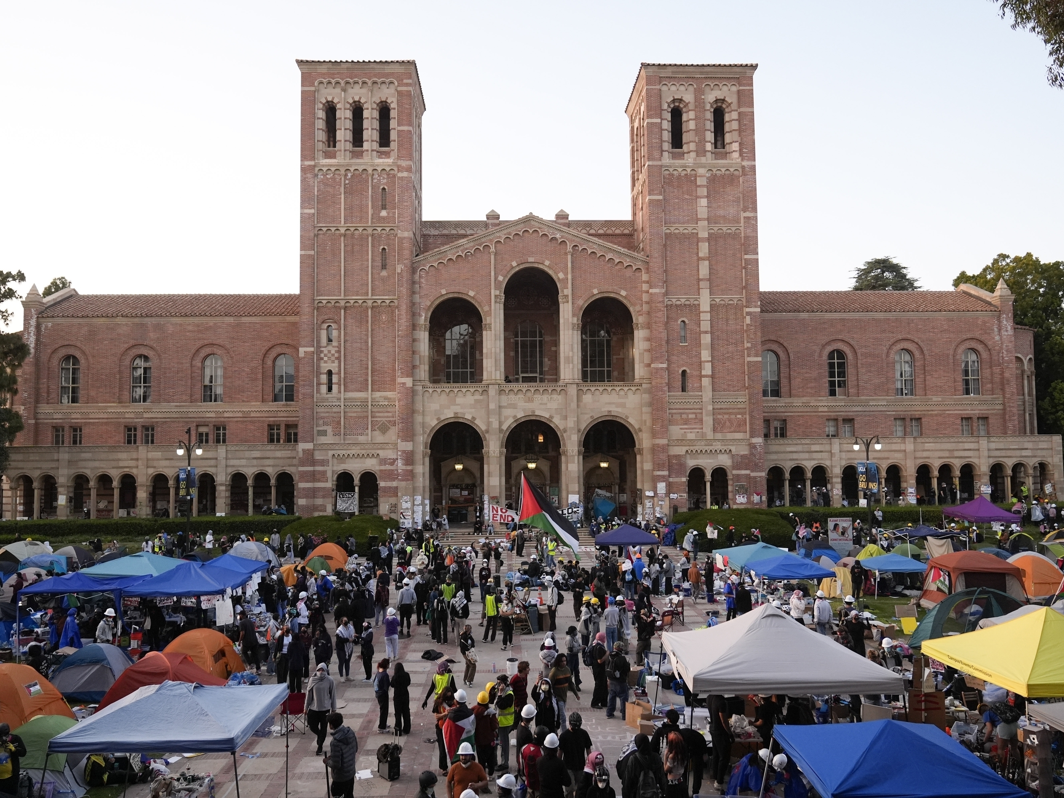 caption: FILE - Demonstrators walk in an encampment on the UCLA campus after clashes between pro-Israel and pro-Palestinian groups, May 1, 2024, in Los Angeles.