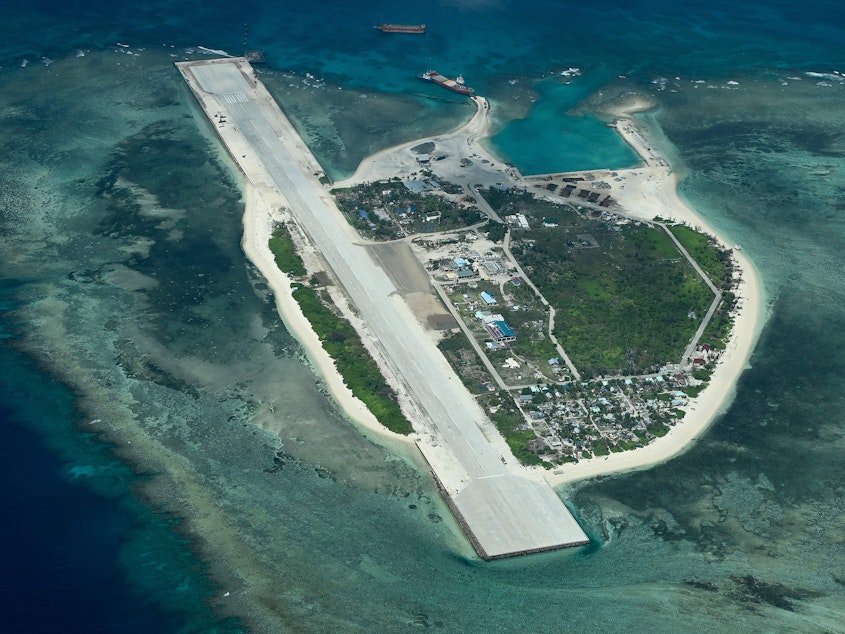 caption: An aerial view taken on March 9, 2023 shows Thitu Island in the South China Sea. - As a Philippine Coast Guard plane carrying journalists flew over the Spratly Islands in the hotly disputed South China Sea, a Chinese voice issued a stern command over the radio: "Leave immediately."