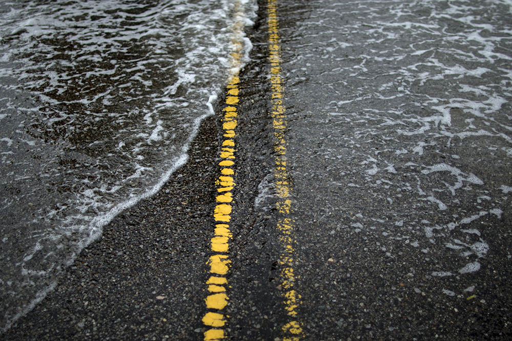 caption: In this Thursday, Oct. 1, 2015 photo, brackish sea water washes over the center line of a street in Charleston, S.C. The National Oceanic and Atmospheric Administration notes that nuisance flooding - that is flooding from ordinary high tides exacerbated by sea level rise and accompanying land subsidence - has increased 400 percent in Charleston since 1960. (AP Photo/Stephen B. Morton)
