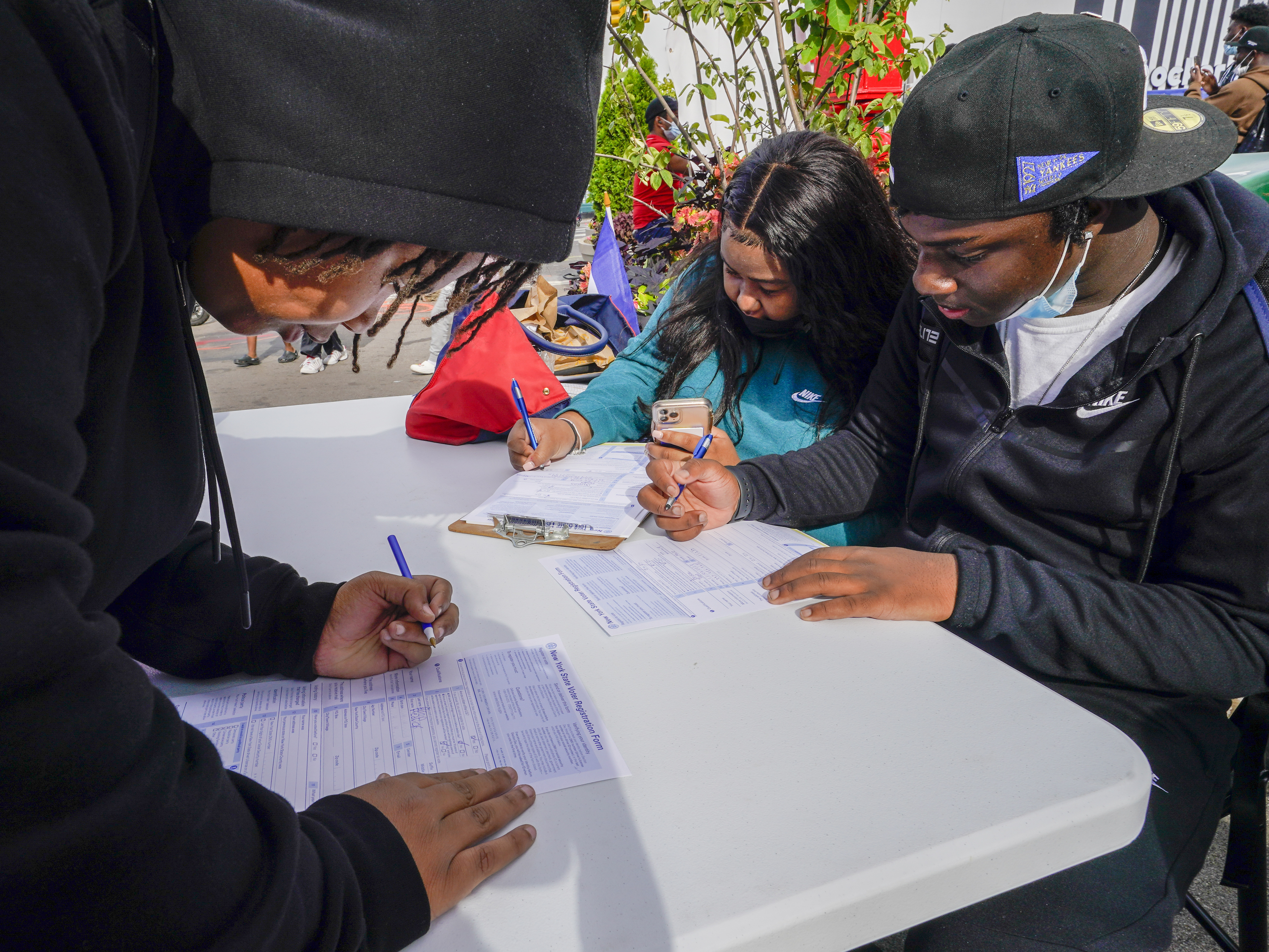 caption: Residents of Brooklyn's Flatbush neighborhood register to vote at a voter registration event on Sept. 29, 2021.