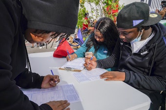 caption: Residents of Brooklyn's Flatbush neighborhood register to vote at a voter registration event on Sept. 29, 2021.