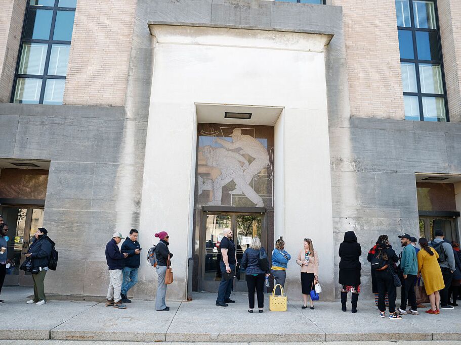 caption: Employees of the Department of Health and Human Services stand in line to enter the Mary E. Switzer Memorial Building on April 01, 2025 in Washington, DC. Widespread layoffs began Tuesday across the agency.