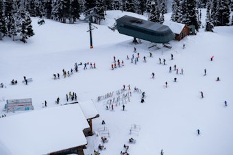 caption: Skiers take to the slopes and to the lodge at Crystal Mountain Resort on Jan. 22, 2021. Crystal banned indoor seating in compliance with Washington state Covid-19 guidelines, so many visitors eat at outdoor tables.
