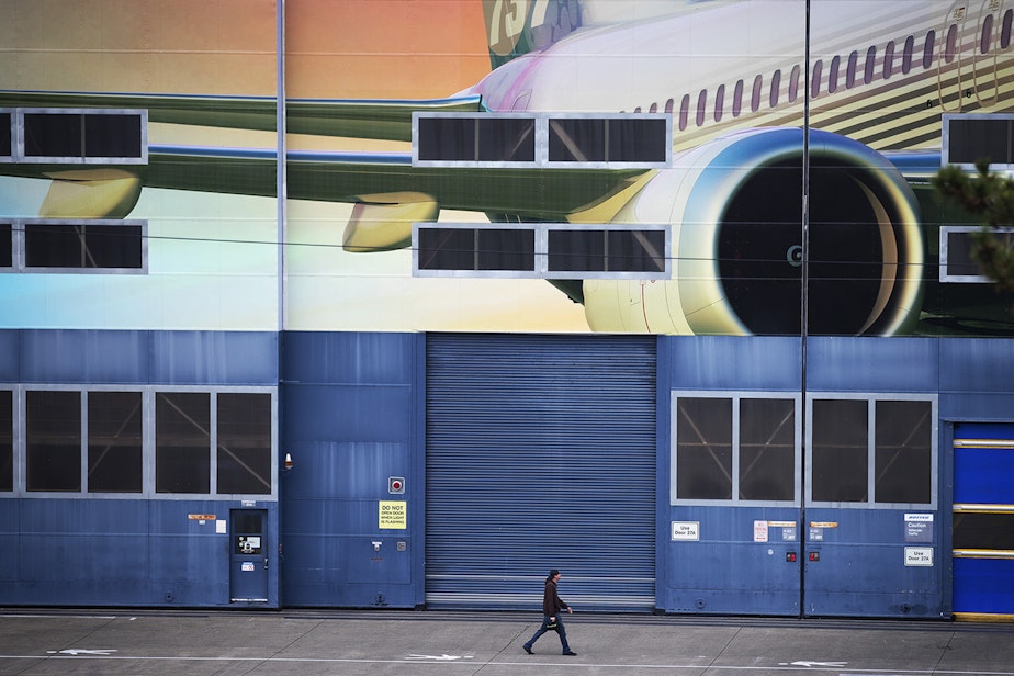 caption: A Boeing employee walks out of the Boeing Renton Factory after shift change on Monday, December 16, 2019, in Renton.