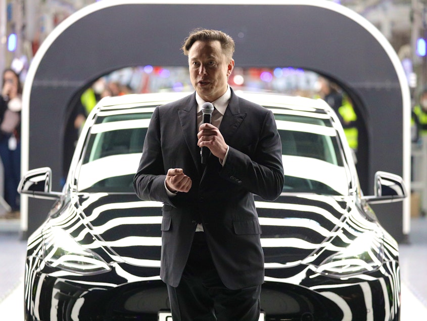 caption: Tesla CEO Elon Musk speaks during the official opening of the new Tesla electric car manufacturing plant near Gruenheide, Germany, on March 22. Musk reportedly wants to lay off 10% of staff because of his worries about the economy.