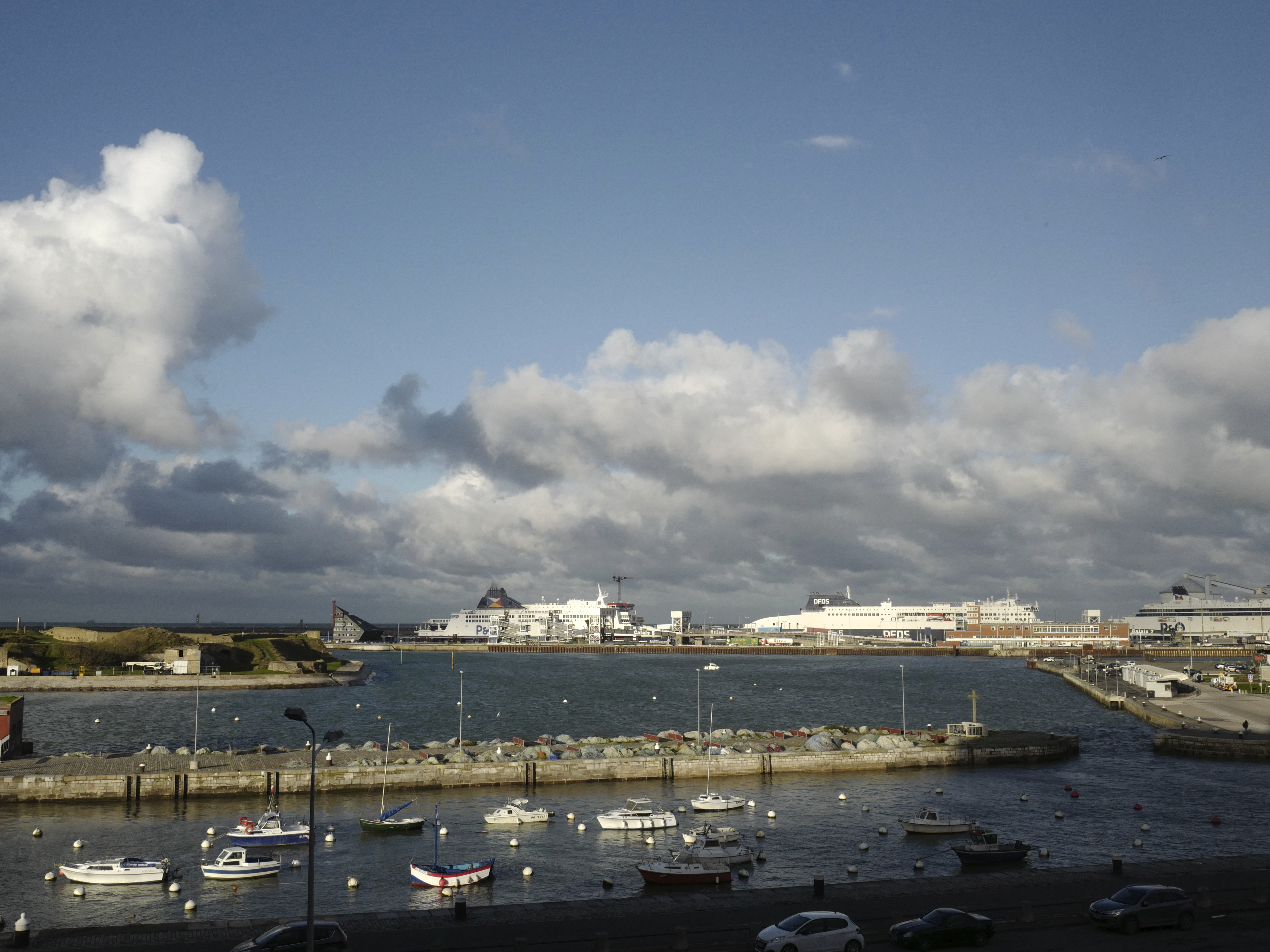 caption: Ferries, background, dock in the port of Calais, northern France, in November 2021. At least 76 people have died crossing the English Channel in 2024, making it the deadliest year on record for small boat crossings.