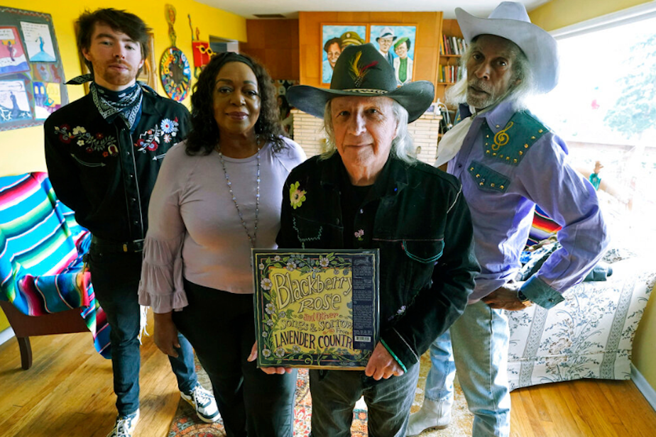 caption: Patrick Haggerty, second from right, the founder and lead singer of Lavender Country, poses for a photo, Friday, Feb. 18, 2022, at his home in Bremerton, Wash., with some of the musicians in his band, Jack Moriarity, left, LoLo Marie, second from left, and Bobby Inocente, right. Haggerty founded the band and recorded a country music album in 1973 that unabashedly explored LGBTQ themes, becoming a landmark that would nonetheless disappear for decades. 