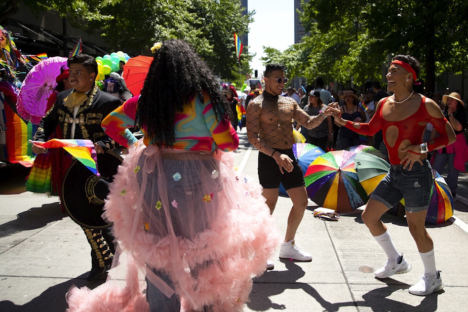 caption: Andres and Chrissy, right, dance while marching with Entre Hermanos, a Latinx LGBTQ+ organization in Seattle, during Seattle’s Pride Parade on Sunday, June 25, 2023, in downtown Seattle.