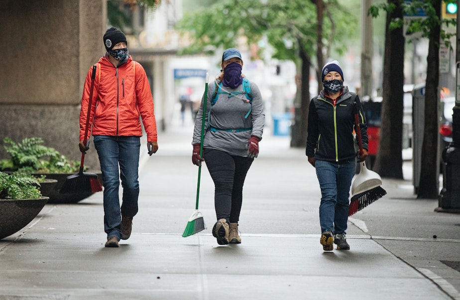 caption: People in downtown Seattle on Sunday, May 31, 2020, arrive with their own cleaning supplies to help tidy the city up again after a night of protests against racialized police violence. The protests were tied to the death of George Floyd, a Black man, at the hands of police. 