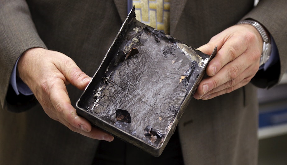 caption: NTSB's Joseph Kolly, holds an fire-damaged battery casing from the Japan Airlines Boeing 787 Dreamliner that caught fire at Boston's Logan Airport, at the NTSB laboratory in Washington, D.C., Jan. 24, 2013.