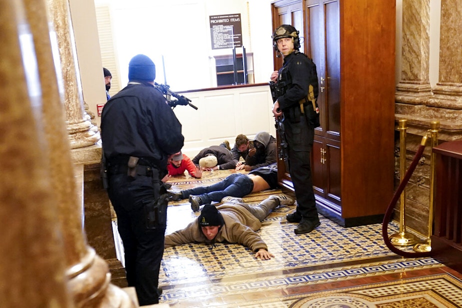 caption: U.S. Capitol Police hold protesters at gun-point near the House Chamber inside the U.S. Capitol on Wednesday, Jan. 6, 2021, in Washington. 