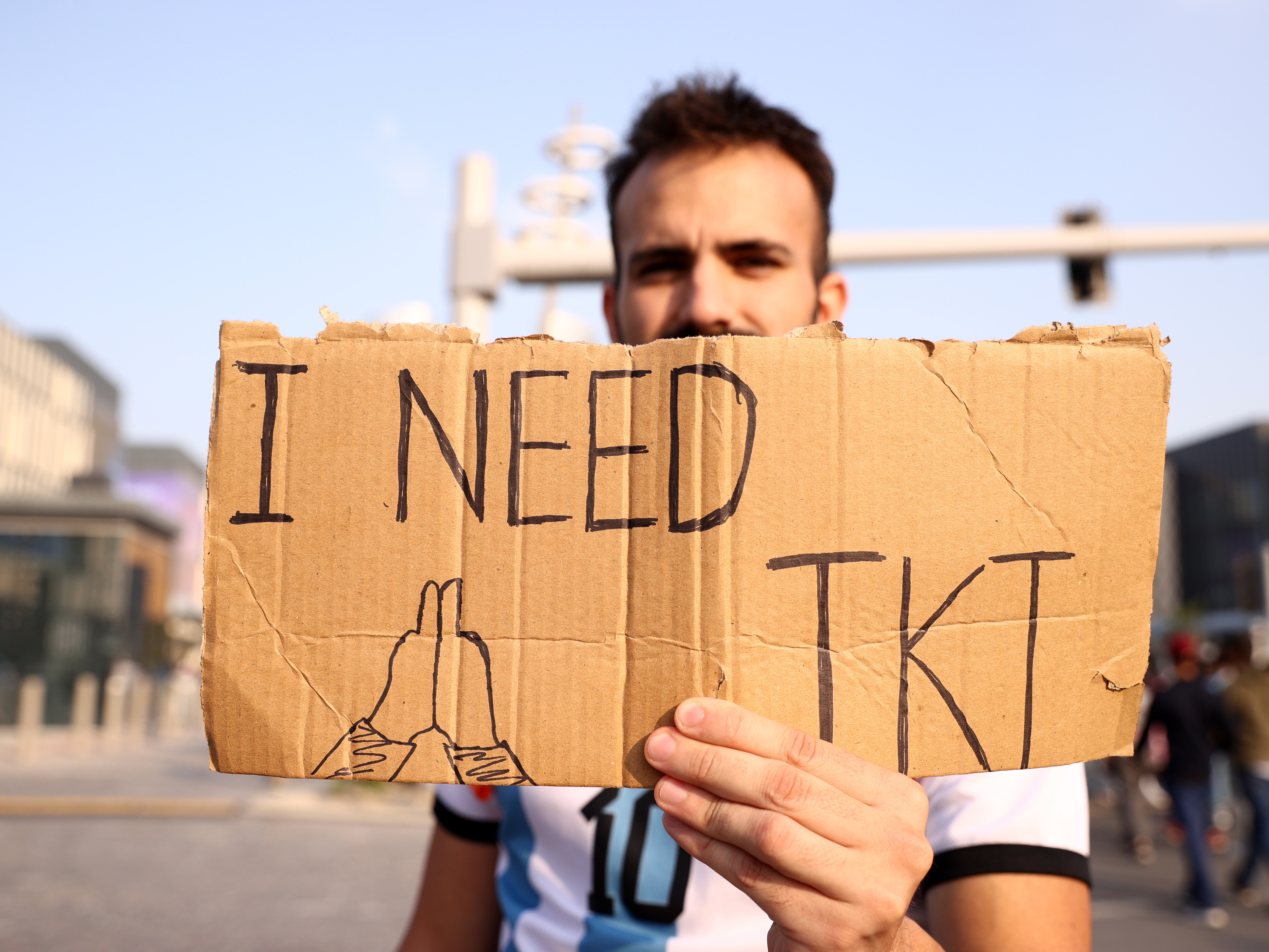 caption: A fan holds a banner asking for a ticket outside the stadium prior to the 2022 FIFA World Cup final between Argentina and France at Lusail Stadium in Lusail City, Qatar, on Dec. 18, 2022.