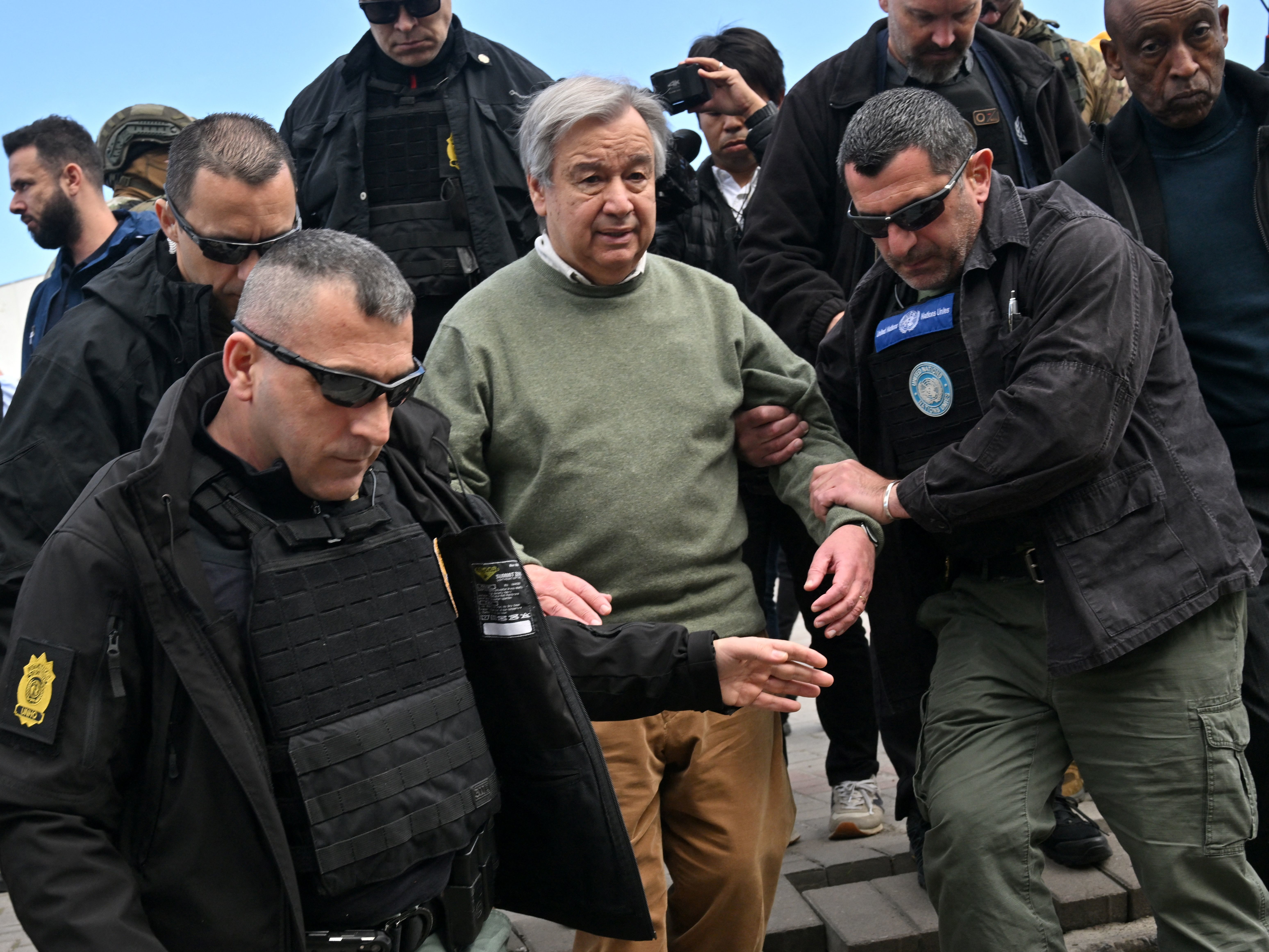 caption: U.N. Secretary-General Antonio Guterres walks with security personnel as his visits Borodyanka, a town outside Kyiv that was devastated by a Russian attack and occupation, on Thursday. Russia sent a deadly attack into the capital as Guterres visited.