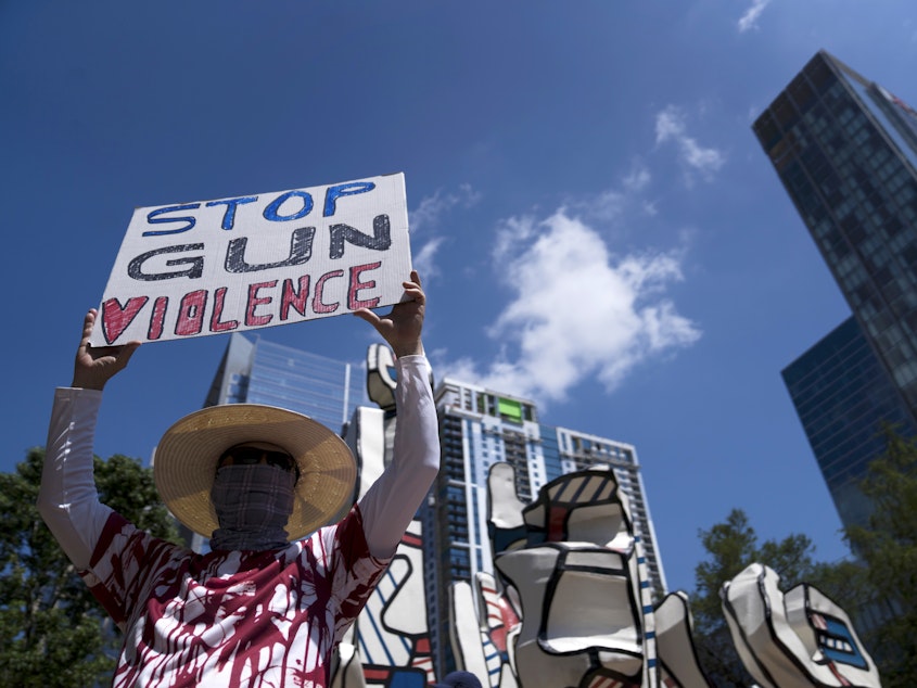 caption: Gun control advocates hold signs during a protest at Discovery Green across from the National Rifle Association Annual Meeting at the George R. Brown Convention Center on Friday in Houston, Texas.