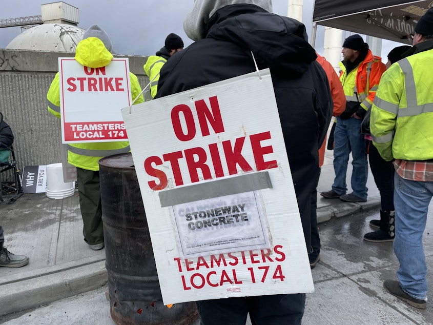 caption: Teamsters union members from Local 174 hold signs and demonstrate outside the Ash Grove Cement plant and Stoneway Concrete yard on East Marginal Way South near the West Seattle Bridge entrance.