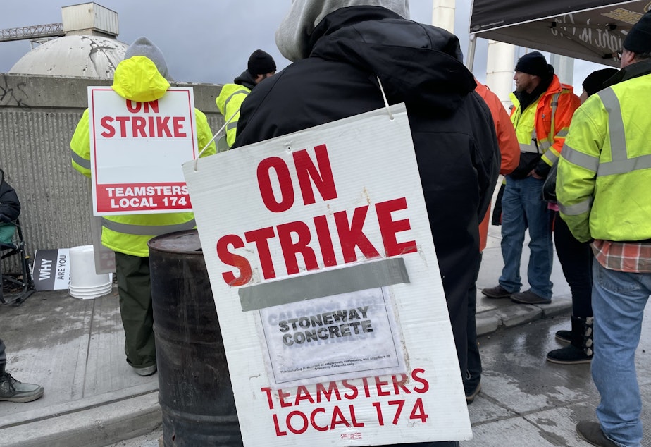 caption: Teamsters union members from Local 174 hold signs and demonstrate outside the Ash Grove Cement plant and Stoneway Concrete yard on East Marginal Way South near the West Seattle Bridge entrance.