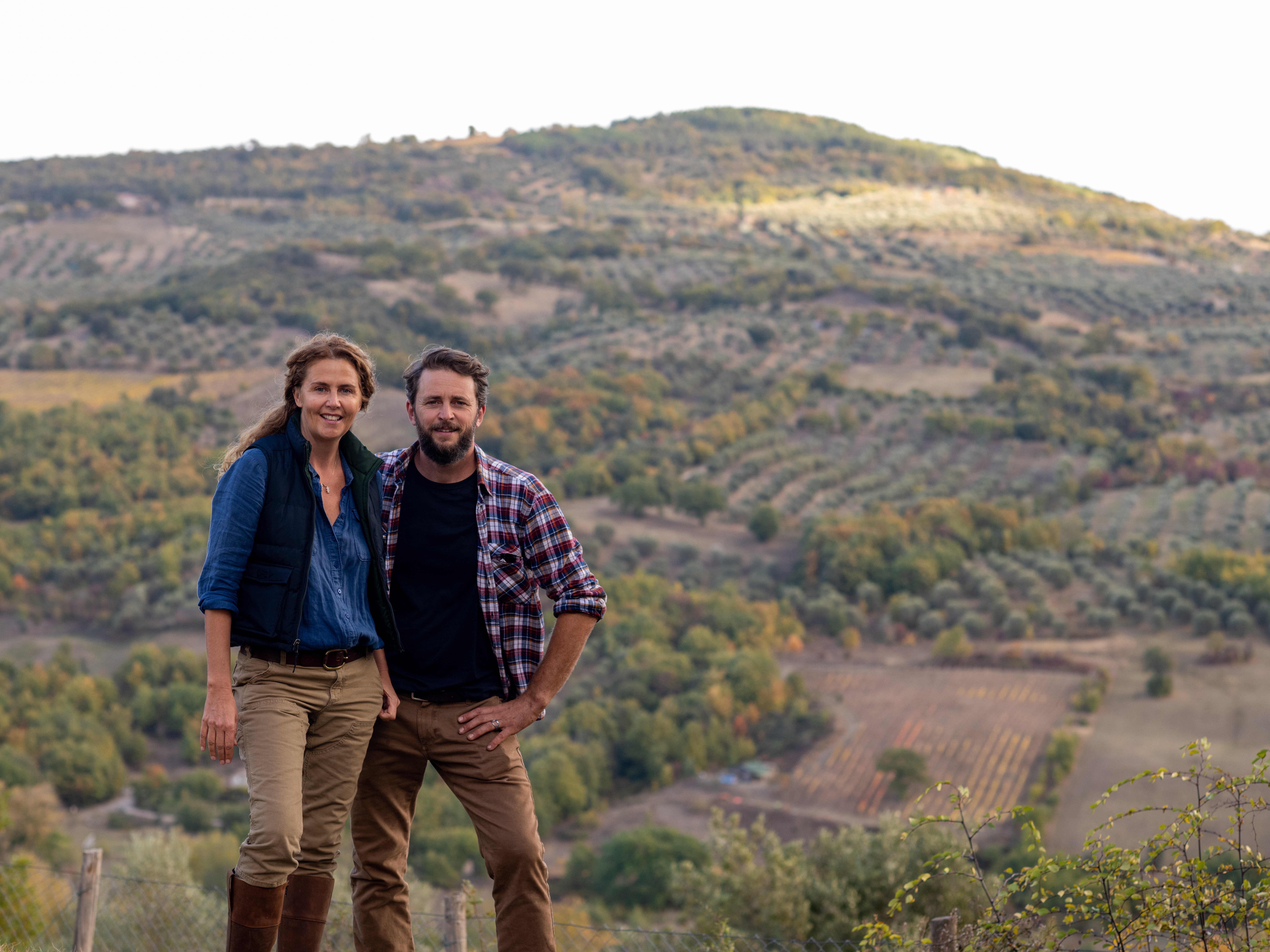 caption: Siblings Marie-Charlotte Piro and Romain Piro stand among some of the olive trees they harvest in Tuscany, Italy, to create their olive oil. Their Olio Piro startup had been exporting all its olive oil to the United States — until new U.S. tariffs moved up their plans to start expanding elsewhere.