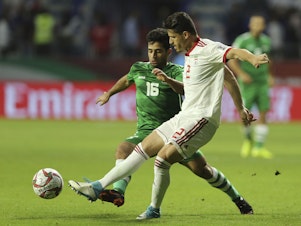 caption: Iranian soccer player Voria Ghafouri (right), then a member of the national soccer team, fights for the ball with Iraqi midfielder Hussein Ali during the AFC Asian Cup soccer match in Dubai in 2019. The semiofficial Fars and Tasnim news agencies reported on Thursday that Iran arrested Ghafouri for insulting the national soccer team and criticizing the government.