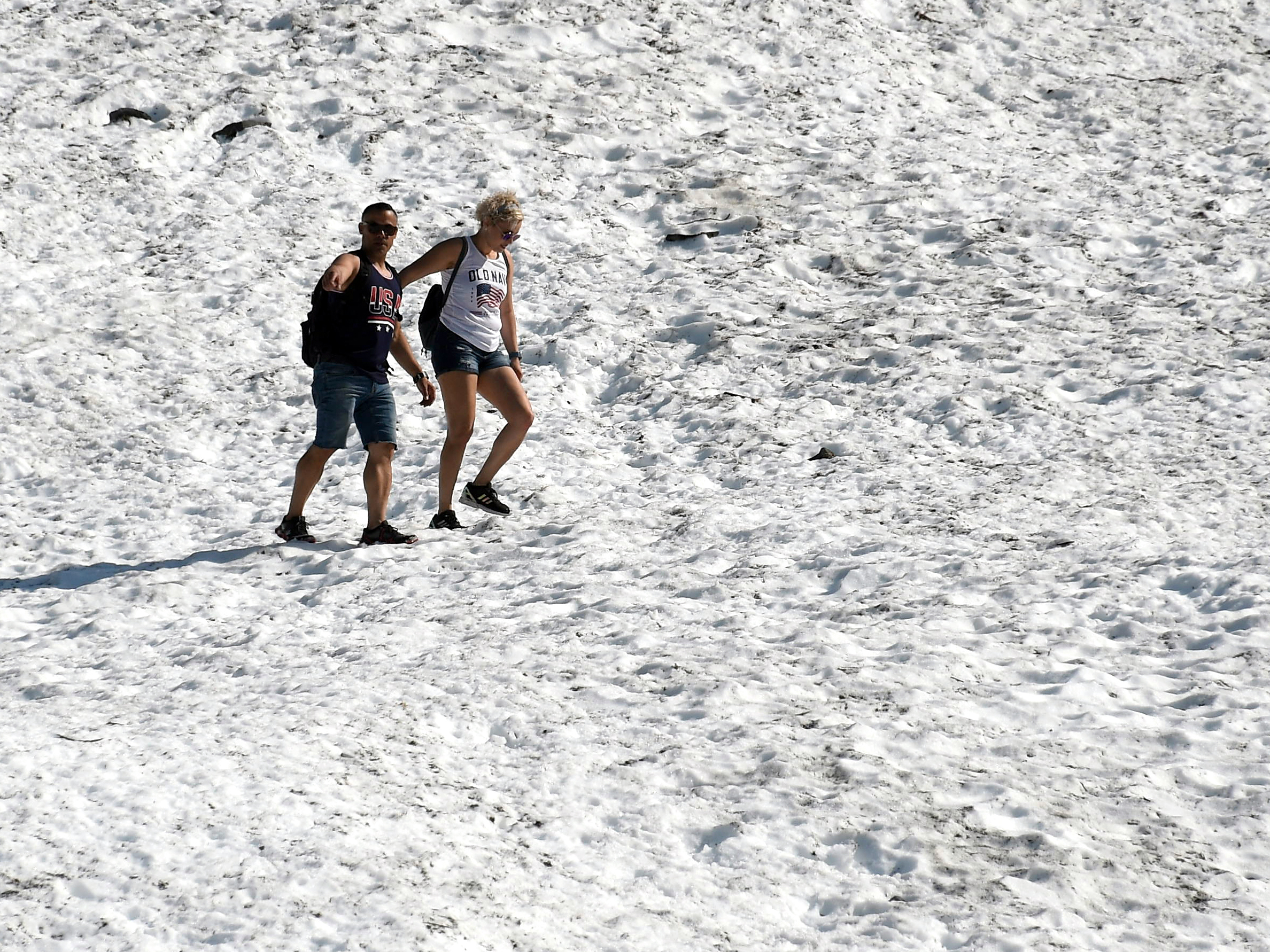 caption: People hike on the Byron Glacier on Thursday in Girdwood, Alaska, southeast of Anchorage. Many cities set heat records amid unusually hot and dry conditions in the area.