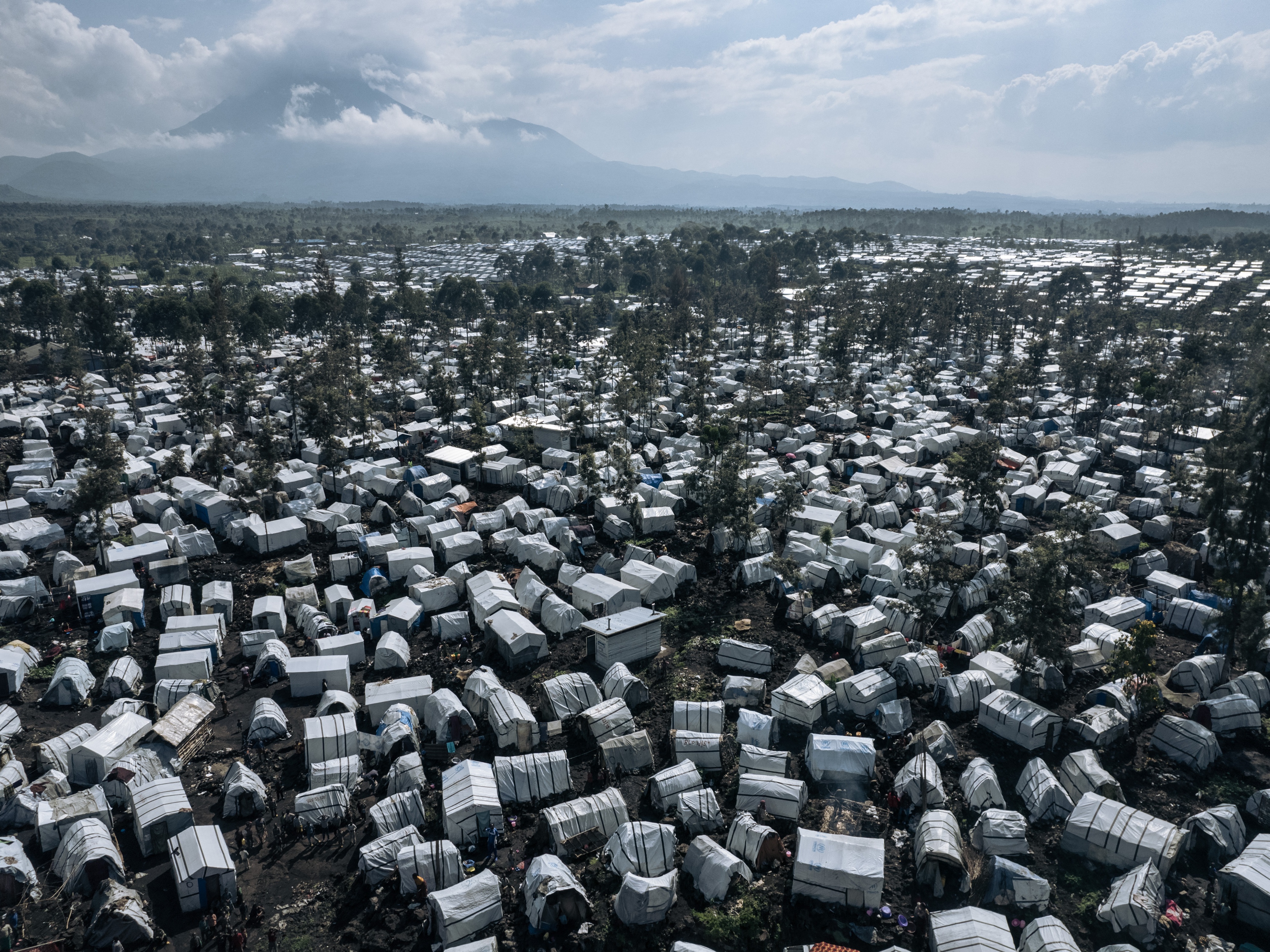 caption: An aerial photograph from 2023 of the Rusayo camp for internally displaced people on the outskirts of Goma in the East of the Democratic Republic of Congo. Hundreds of thousands of Congolese have found refuge around Goma after fleeing fighting further north. Two new reports document a 'staggering' increase in rapes over the past year.