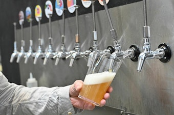 caption: A pint of beer is poured at Pressure Drop Brewery, in north London, in 2022.