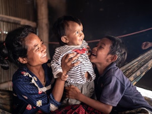 caption: Ten-month-old Ahmin Esas, who was born with clubfoot, shares a moment with his mother and brother in the family's home near Battambang, Cambodia. As a single parent with limited means, his mother, Pho Sok overcame many challenges to ensure her son could receive the treatment he needed.