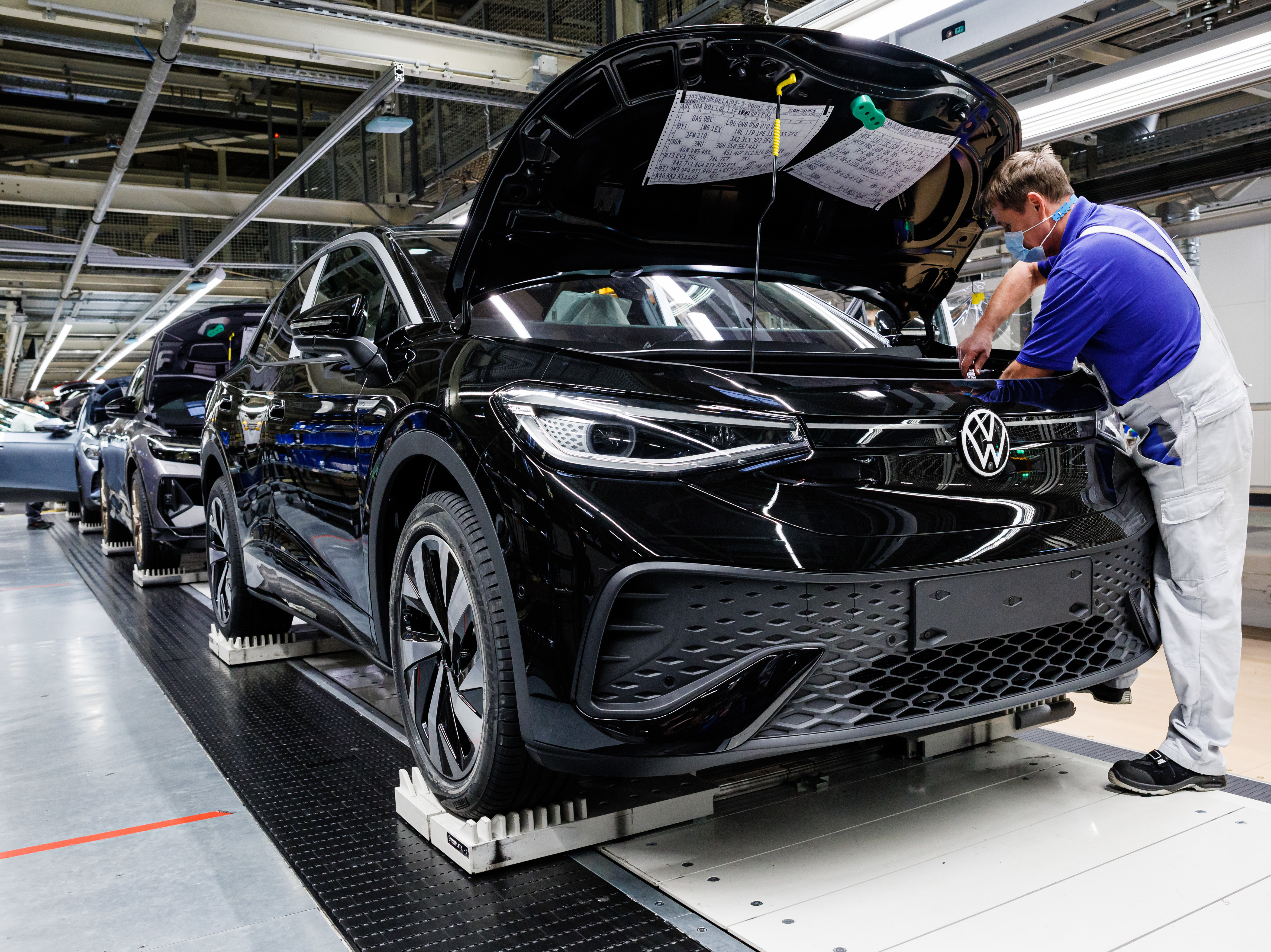 caption: A worker assembles Volkswagen electric cars at the company's plant in Zwickau, Germany on Jan. 27. Automakers like Volkswagen are racing to secure enough metals to power the batteries needed to make electric vehicles.