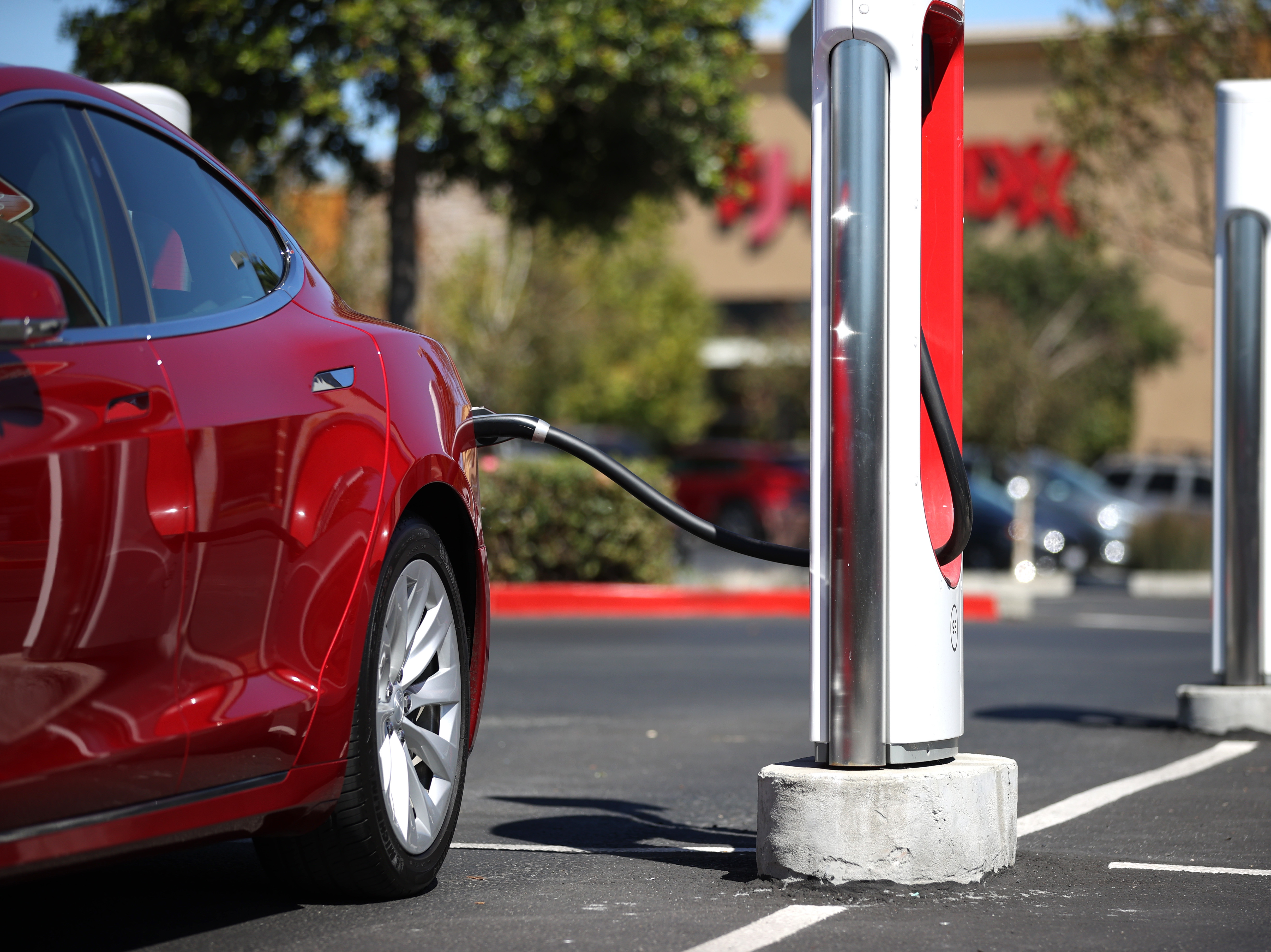 caption: A Tesla car powers up at a charging station in Petaluma, Calif. on Sept. 23, 2020. Auto makers are trying to convince would-be electric car buyers to adopt new habits to power their vehicles.