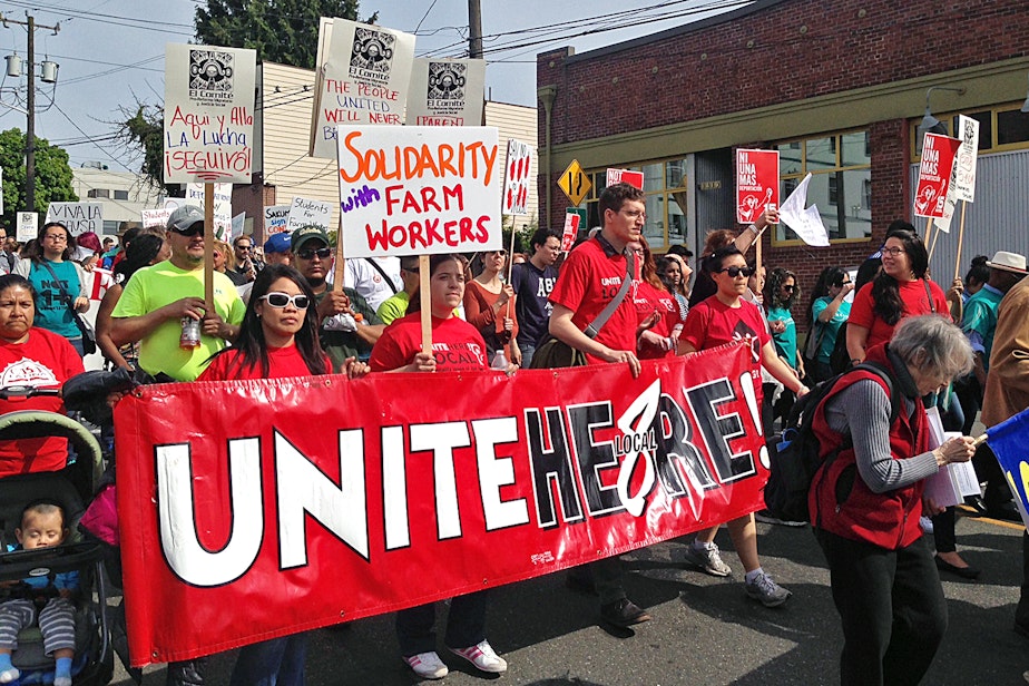 caption: People walk in the May Day labor march in Seattle on Friday, May 1, 2015.