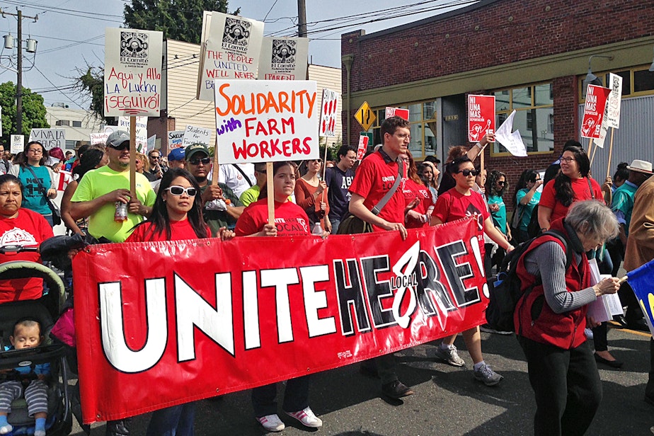 caption: People walk in the May Day labor march in Seattle on Friday, May 1, 2015. 