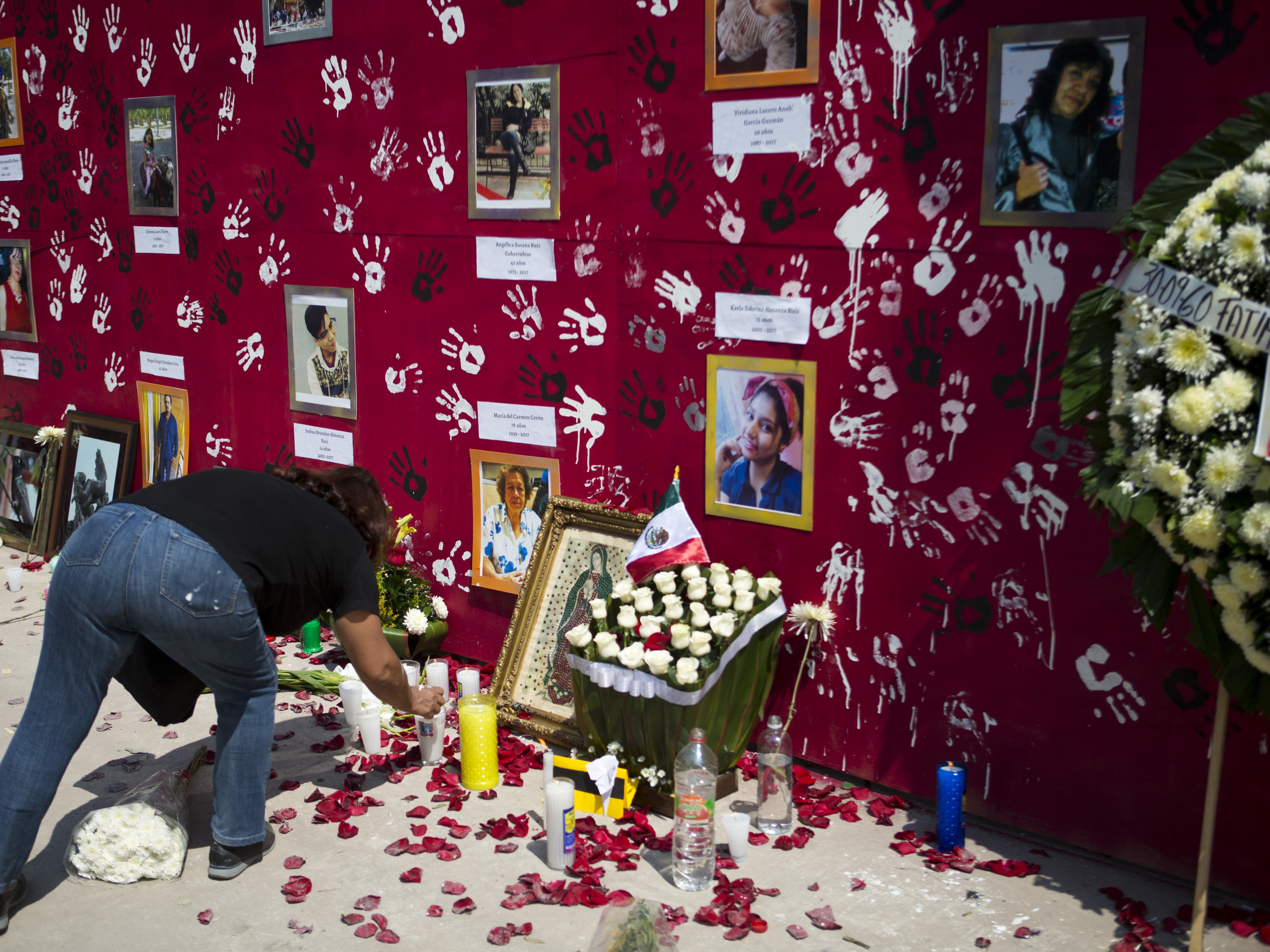 caption: A memorial to the nine people killed when unit 1C at the Multifamiliar Tlalpan housing complex collapsed, on the one month anniversary of the magnitude 7.1 earthquake in Mexico City, Thursday, Oct. 19, 2017.