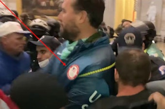caption: A screenshot from the Jan. 6 U.S. Capitol insurrection allegedly shows gold medalist swimmer Klete Keller wearing an Olympic jacket while inside the Rotunda. He is facing three criminal counts: obstructing law enforcement, knowingly entering a restricted building without lawful authority and violent entry and disorderly conduct on Capitol grounds.
