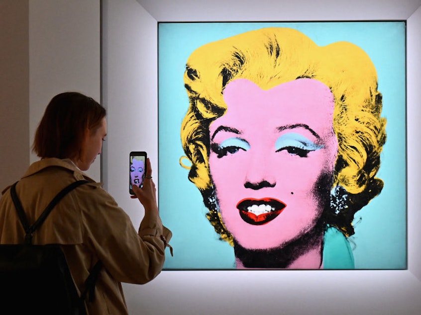 caption: A woman takes a photo of Andy Warhol's 'Shot Sage Blue Marilyn' on April 29 during Christie's 20th and 21st Century Art press preview in New York City.