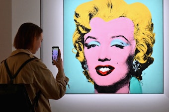 caption: A woman takes a photo of Andy Warhol's 'Shot Sage Blue Marilyn' on April 29 during Christie's 20th and 21st Century Art press preview in New York City.