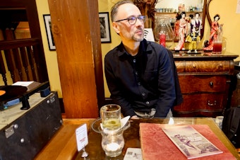 caption:  Paul Kikuchi next to the Califone in the Panama Hotel Tea Room
