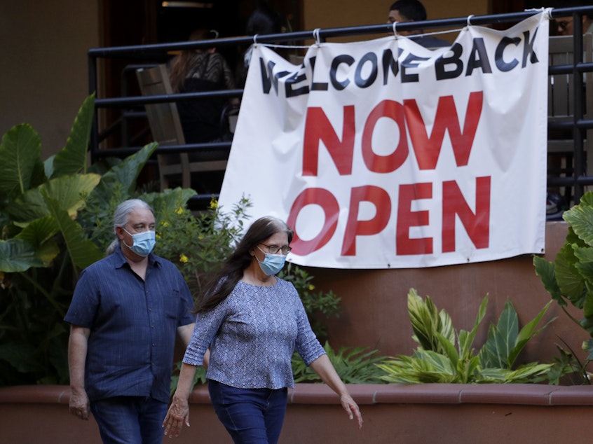 caption: Visitors to the River Walk in San Antonio pass a reopened restaurant on May 18. Texas Gov. Greg Abbott says bars and bowling alleys are on the list of businesses that can reopen at 25% beginning Friday, and restaurants can increase to 50% capacity as the state continues to go through phases to reopen.