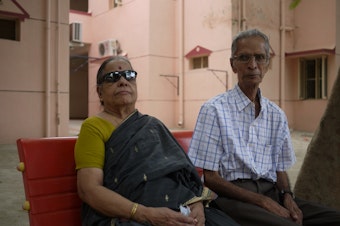caption: Mahadevan Iyer and a friend sit outside his apartment at a senior living community near Chennai, India.  